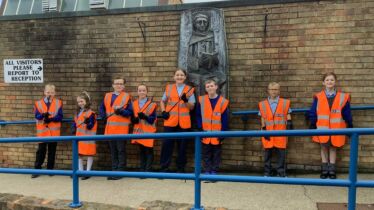 School litter pick kits from J&B recycling. School kids lined up with high vis jackets on