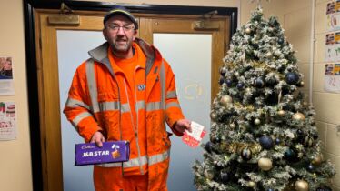 J&B Recycling team member next to Christmas tree at head office