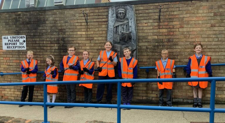 School litter pick kits from J&B recycling. School kids lined up with high vis jackets on